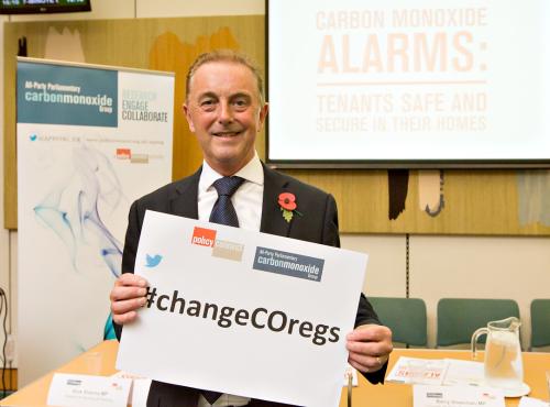 Chris Bielby holding a sign saying #ChangeCORegs