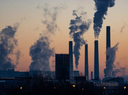 A cityscape with factory chimneys and lots of smoke