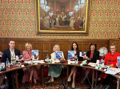 picture of the chair, speakers and panellists holding up a report