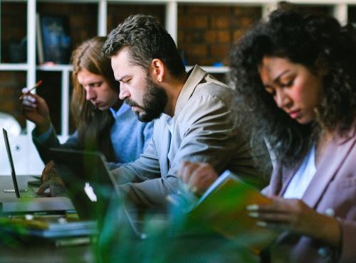 Image of three workers on their laptops.